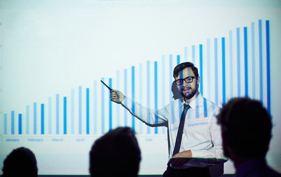 What is pitch deck - Image of a man explaining a growth chart in a presentation